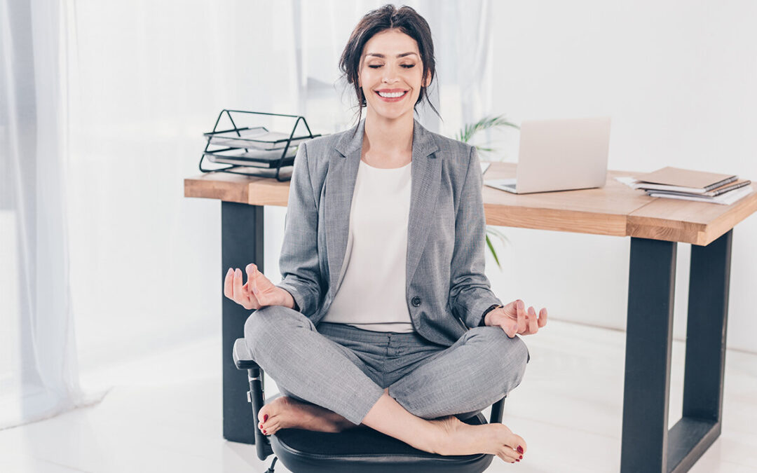 Femme faisant du yoga devant son bureau