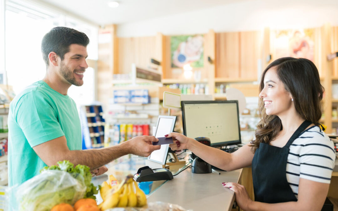Client souriant utilisant une carte de fidélité à la caisse d'un magasin