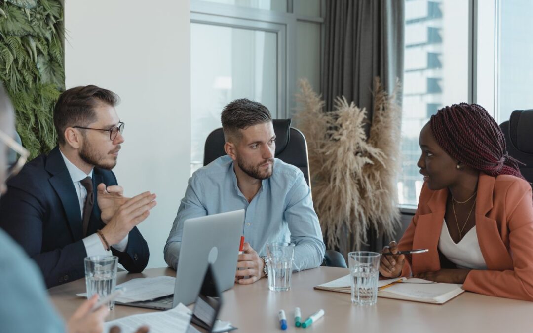 un groupe de professionnels multiculturels en pleine discussion autour d'une table de réunion dans un bureau moderne et lumineux